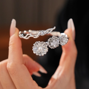 Detail of silver vintage flower bangle with pearl and cubic zirconia on a hand