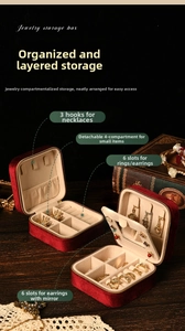 Detail of red velvet jewelry box featuring necklace hooks, ring slots, and earring board