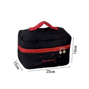 Détail de la grande trousse à maquillage avec broderies rouges et zip en forme de cœur