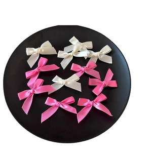 Pink and beige satin ribbon bow hair clips set on black tray for balletcore styling