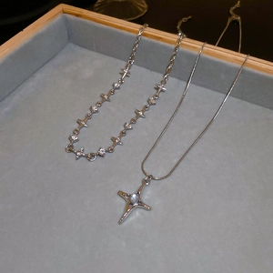 Close-up of double-layer star necklaces with diamonds on grey velvet tray