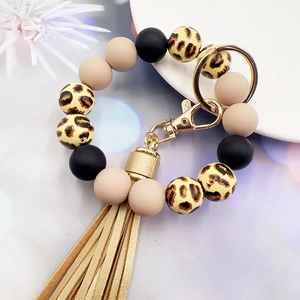 Close-up of leopard print silicone beads with tassel and golden metal keychain ring