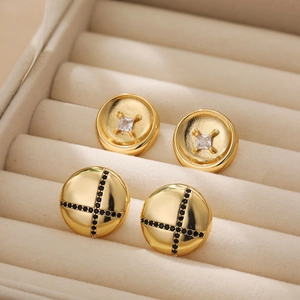 Detailed macro view of 18K gold earrings with black zircon and clear square stones