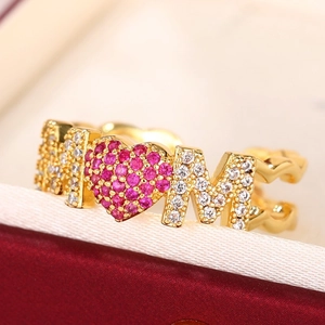Macro detail of gold MOM ring with white and pink cubic zirconia micro-pave setting