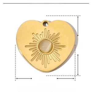 Macro detail of golden heart pendant with sunray texture and natural stone inlay