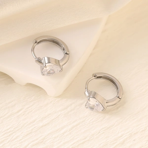 Close-up of silver earrings featuring heart-shaped cubic zirconia on geometric stands
