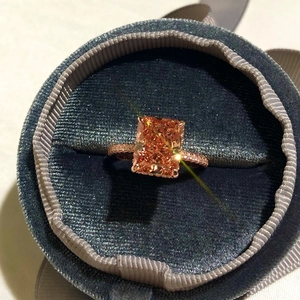 Macro detail of rectangle orange gemstone ring with rose gold pavé band in velvet box