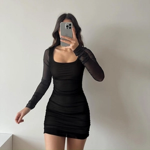 Robe courte noire moulante avec manches longues en résille et détails froncés