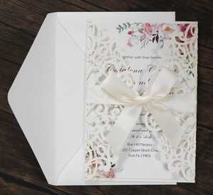 Laser cut lace wedding invitation with floral insert and elegant satin ribbon bow