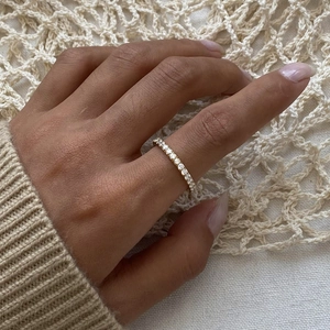 Close-up of a gold stainless steel band ring set with sparkling cubic zirconia stones