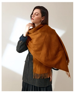 Detailed texture of caramel cashmere scarf with elegant fringe during autumn season