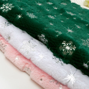 Faux rabbit fur fabric with silver snowflake patterns in dark green, white and pink