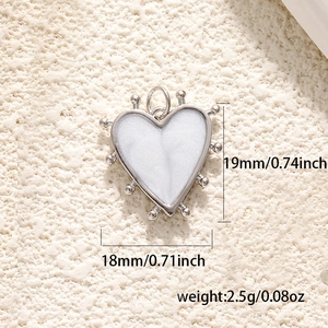 Detail shot of silver heart pendant with white enamel inlay and beaded edge details