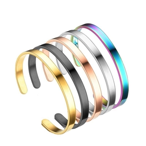 Stack of open metal bangles in gold, black, rose gold, silver, and rainbow colors