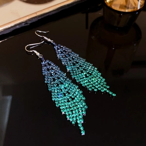 Vue détaillée des boucles d'oreilles à franges dégradées bleu-vert en strass brillants