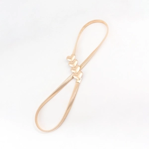 Close-up of gold metal spring belt featuring four elegant heart-shaped buckle ornaments