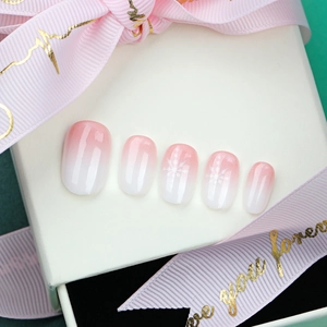 French ombre pink and white press-on nails with delicate snowflake designs for Christmas