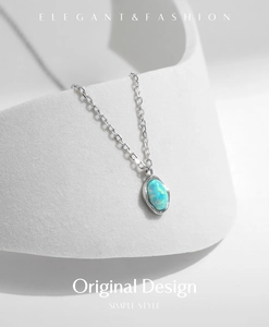 Macro detail of oval blue opal pendant on a silver S925 chain with elegant wave design