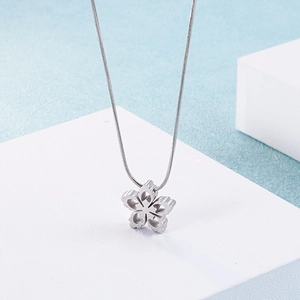 Close-up of a silver stainless steel necklace featuring a hollow snowflake flower pendant