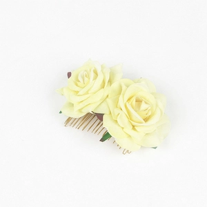 Detail of yellow fabric roses on a gold metal hair comb for bridal styling