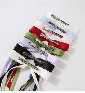 Flat lay of multiple colorful ribbon bow hair clips with metal alligator clips
