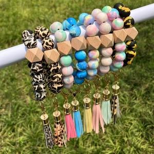 Outdoor close-up of silicone beaded bracelets with sunflower prints and leather tassels