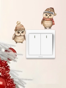 Détail des stickers muraux chouettes de Noël mignons posés autour d'un interrupteur mural