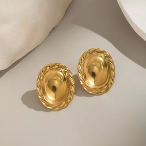 Minimalist oval gold earrings with textured scalloped edges and polished metallic finish