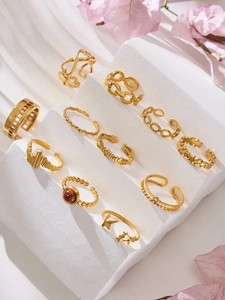 Macro view of assorted 18k gold plated open rings on textured stone display steps