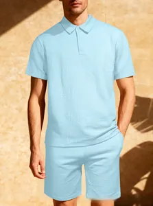 Dettaglio del tessuto a nido d'ape celeste sul set estivo da uomo con polo e pantaloncini