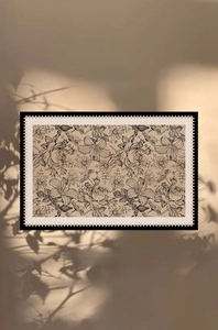 Detailed close-up of beige vintage floral rug with decorative black and white edging