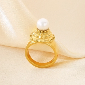 Bague en acier inoxydable texturé avec perle blanche sur fond de soie champagne