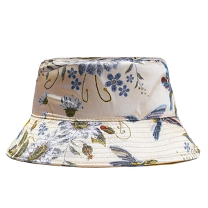 Detail of satin bucket hat with floral pattern, bird print and metallic eyelets