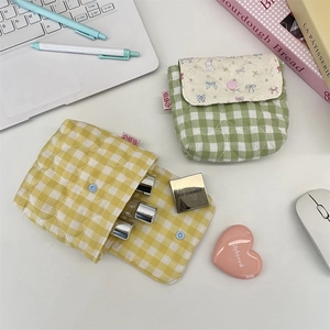 Close-up of quilted plaid cosmetic bags with magnetic flap closure and inner slots