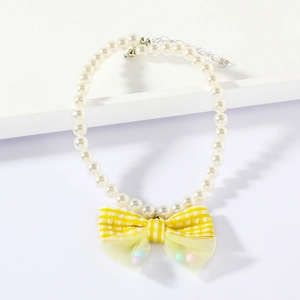 Detail of pet pearl necklace with yellow plaid bow and colorful mesh ball pendant