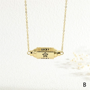 Macro detail of golden rotating cylinder pendant with Lucky engraving and star zircon