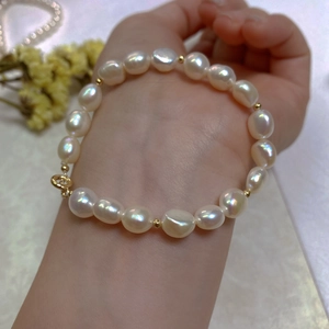 Close-up of natural baroque pearl bracelet with 14k gold accents on a model's wrist
