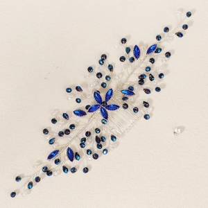 Detailed close-up of a silver floral hair comb with dark blue crystals and rhinestones