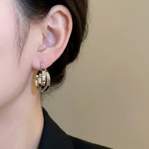 Minimalist silver interlocking double hoop earrings for women shown on model