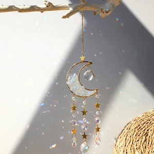 Golden moon suncatcher with rainbow crystals and star charms hanging on a branch