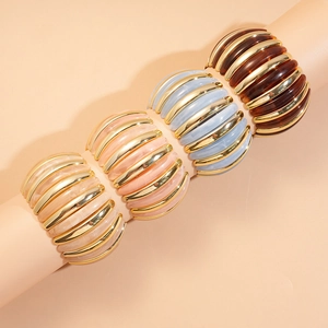 Detail of wide resin beaded bracelets with golden metal spacers in various colors