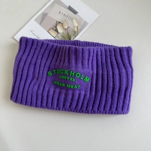 Detail des lila Strickstirnbandes mit grüner Stockholm-Stickerei und Rippenstruktur