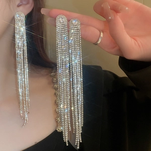Detail of silver long tassel drop earrings with sparkling oval zircon stones in macro view