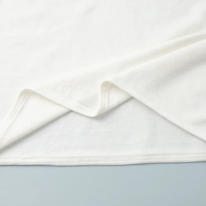 Detail of the high-density white knitted fabric texture and premium overlock edge stitching