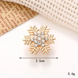 Macro detail of golden snowflake charm with rhinestones measuring 2.5cm and weighing 5.6g