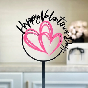 Detail of Happy Valentine's Day acrylic cake topper with pink double heart design