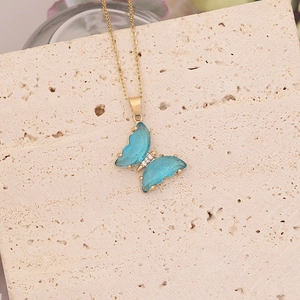 Collier papillon doré élégant avec ailes en cristal bleu et accents de zircon blanc brillant