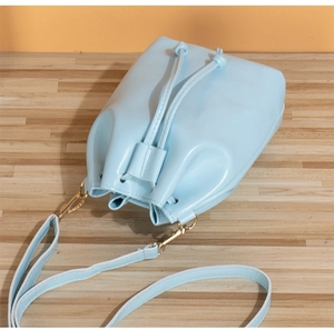 Top view of a light blue bucket bag showing drawstring closure and pale gold hardware