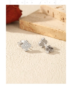 Vue détaillée des boucles d'oreilles trèfle en argent S925 serties de pierres VVS1 blanches