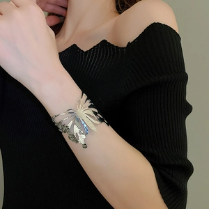 Silver hollow butterfly wide open cuff bracelet worn by a model on arm closeup